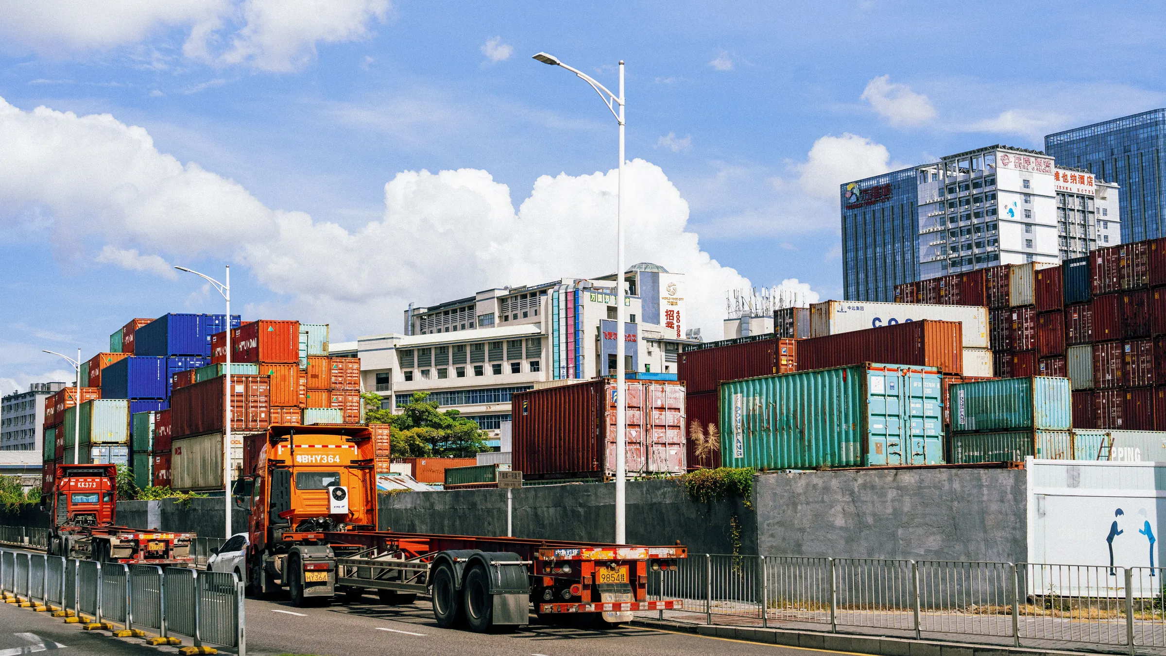 Bãi container nhộn nhịp dưới trời nắng, xe đầu kéo đang chở container
